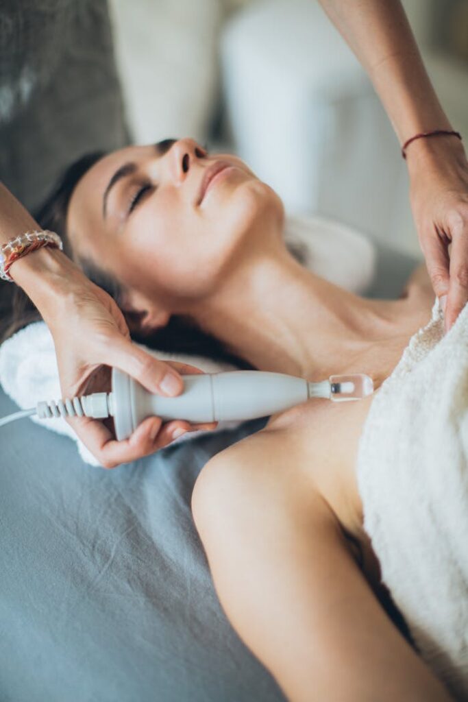 Young woman relaxing during a spa treatment with laser therapy for skincare and wellness enhancement.